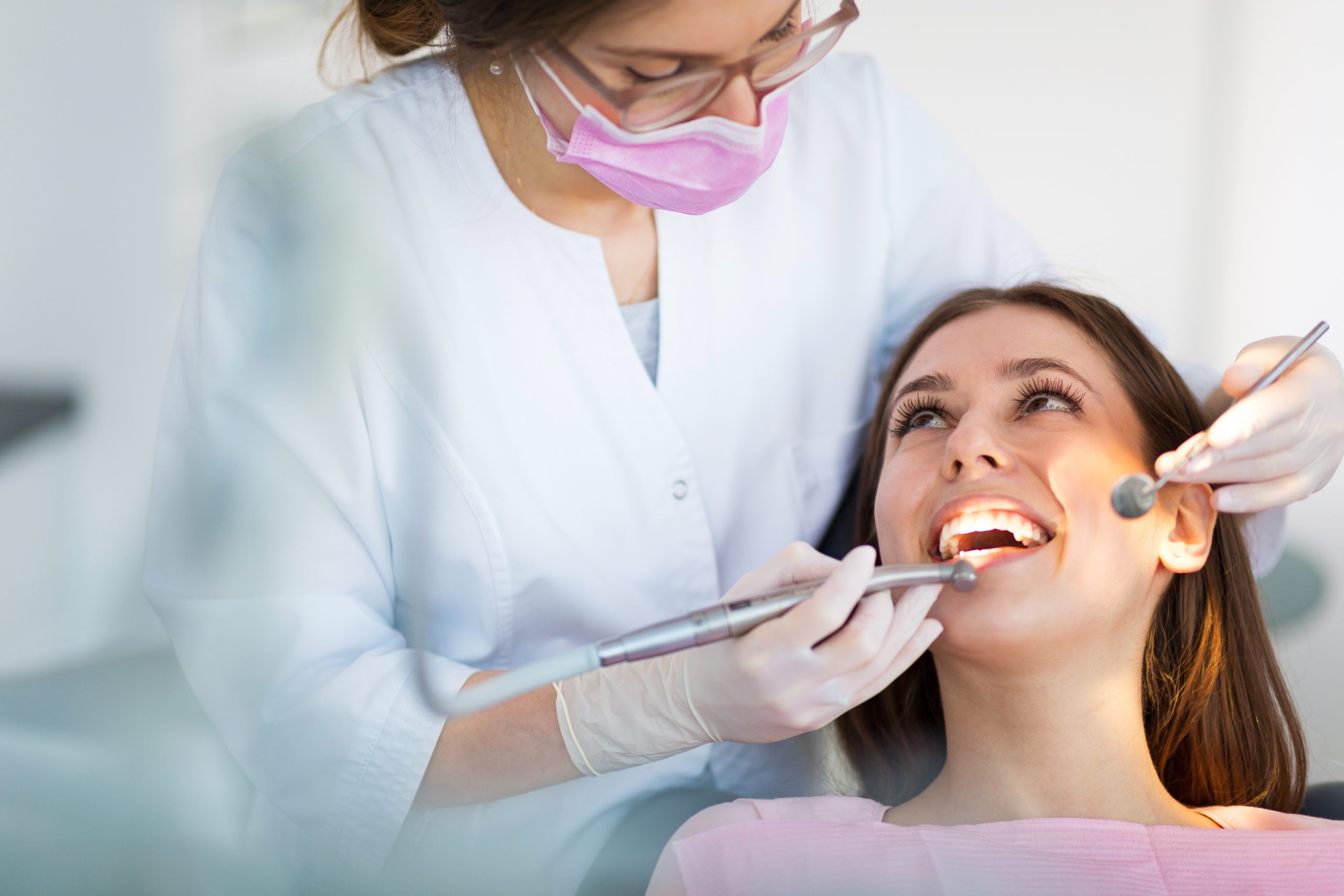 Woman smiling at her dentist during a dental procedure